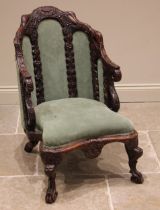 A Ceylonese carved wood and upholstered armchair, 19th century, the arched frame profusely carved