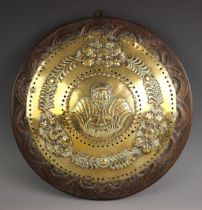 A pierced brass convex circular repousse wall plaque, probably 17th century Dutch, modelled with a