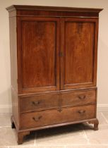 A George III mahogany gentleman's wardrobe, the moulded cornice over a pair of flame mahogany doors,