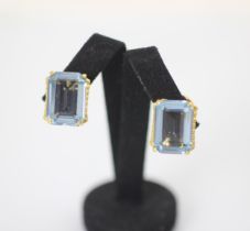 A pair of blue synthetic spinel earrings, the emerald cut blue stones claw set in yellow metal