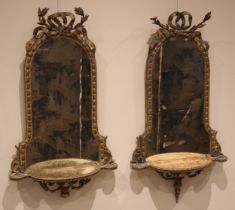 A pair of mid-19th century giltwood and gesso mirrored wall shelves, each with an acanthus and