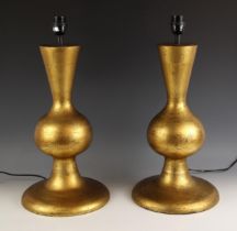 A pair of Oka gilt wooden table lamps, gourd form, leading to a spreading circular base, 56cm