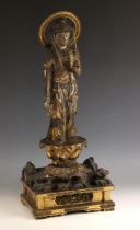 A South East Asian lacquered and gilt highlighted carved wood figure, 19th century, the deity