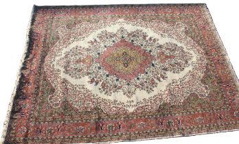 A Kashan pattern carpet in ivory, green and salmon pink colourways, the central ogee medallion