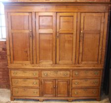 A George III honey oak housekeepers cupboard, the moulded cornice over an arrangement of four