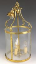 An Edwardian gilt metal hall lantern, of cylindrical form set with curved clear glass panels, the