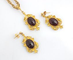 A suite of untested garnet jewellery, comprising pair of earrings and pendant, the cabochon red