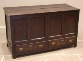 An early 18th century oak mule chest, the twin plank top over four inverted panels and a pair of lip