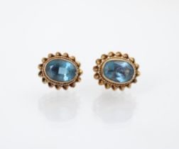 A pair of 9ct yellow gold untested blue topaz earrings, the oval cut stones within gold rope twist