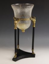 A modern Neoclassical style storm lantern, the tri-form base supporting three brass mounted columns,