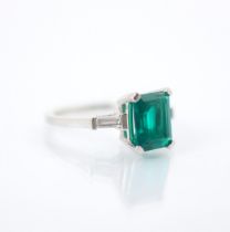 A synthetic emerald and diamond set ring, the emerald cut synthetic emerald set with white metal