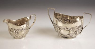 An Edwardian silver milk jug, 'JS' Birmingham 1904, the reeded handle above embossed floral body