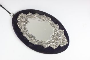 A continental white metal wall hanging mirror, the oval shaped mirror with floral and garland
