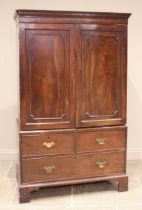 A George III mahogany linen press, the dentil moulded cornice over a pair of beaded cupboard doors