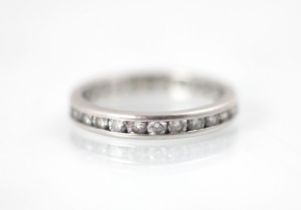 A platinum diamond full eternity ring, the twenty six round cut diamonds channel set in a plain