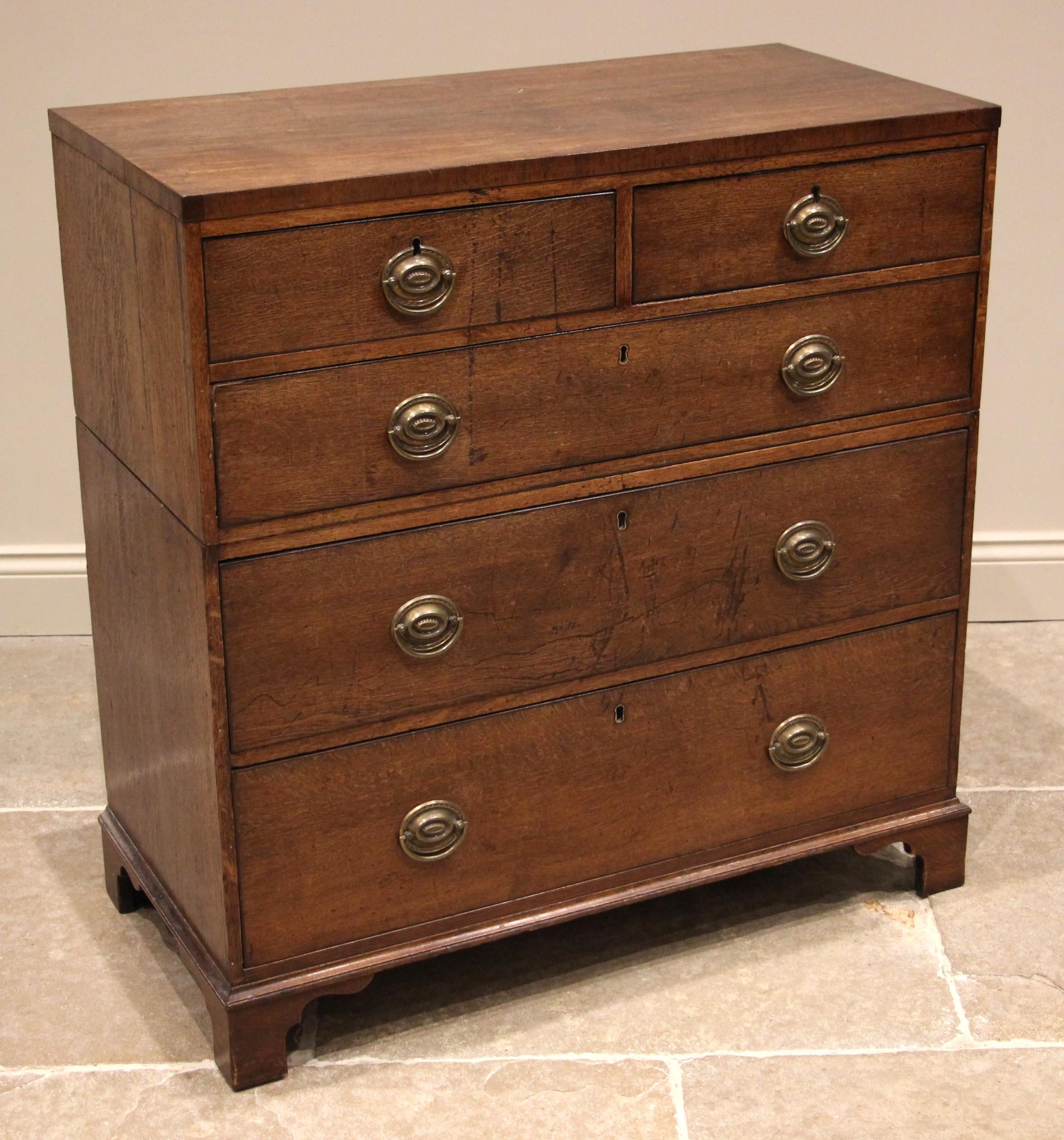 A late George III oak twin section chest of drawers, formed with two short over three long graduated