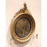 A Regency girandole wall mirror, with a leafy fruit crest over the moulded circular frame applied