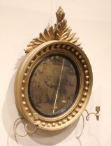 A Regency girandole wall mirror, with a leafy fruit crest over the moulded circular frame applied