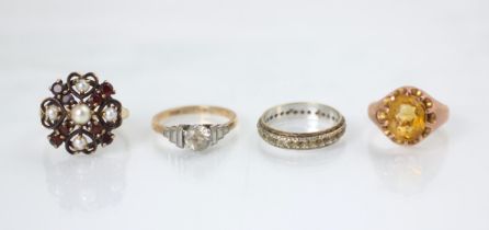 A group of four rings, including a yellow metal citrine set signet style ring, stamped 9ct, ring