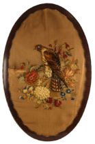 An oval stumpwork panel of large proportions, late 19th or early 20th century, depicting a bird of