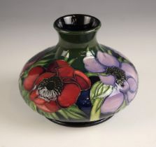 A Moorcroft ‘Anemone’ vase, the body tube lined with a floral spray to a dark green ground,
