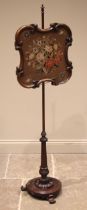 A William IV rosewood pole screen, the glazed needlework screen within a scroll moulded frame,