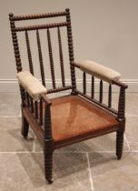 A mahogany bobbin turned armchair, mid to late 19th century, the bobbin frame enclosing a cane