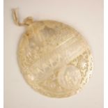 A mother of pearl carved abalone shell, early 20th century, the top section relief carved after