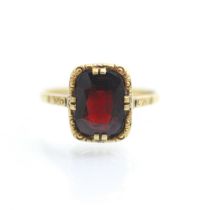 A 19th century style untested garnet ring, the central cushion cut stone within yellow metal