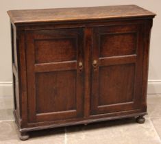 An 18th century and later oak spice cupboard, the rectangular moulded top over canted corners