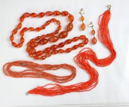 A selection of beads, including a string of coral barrel shaped beads, with base metal fastening,