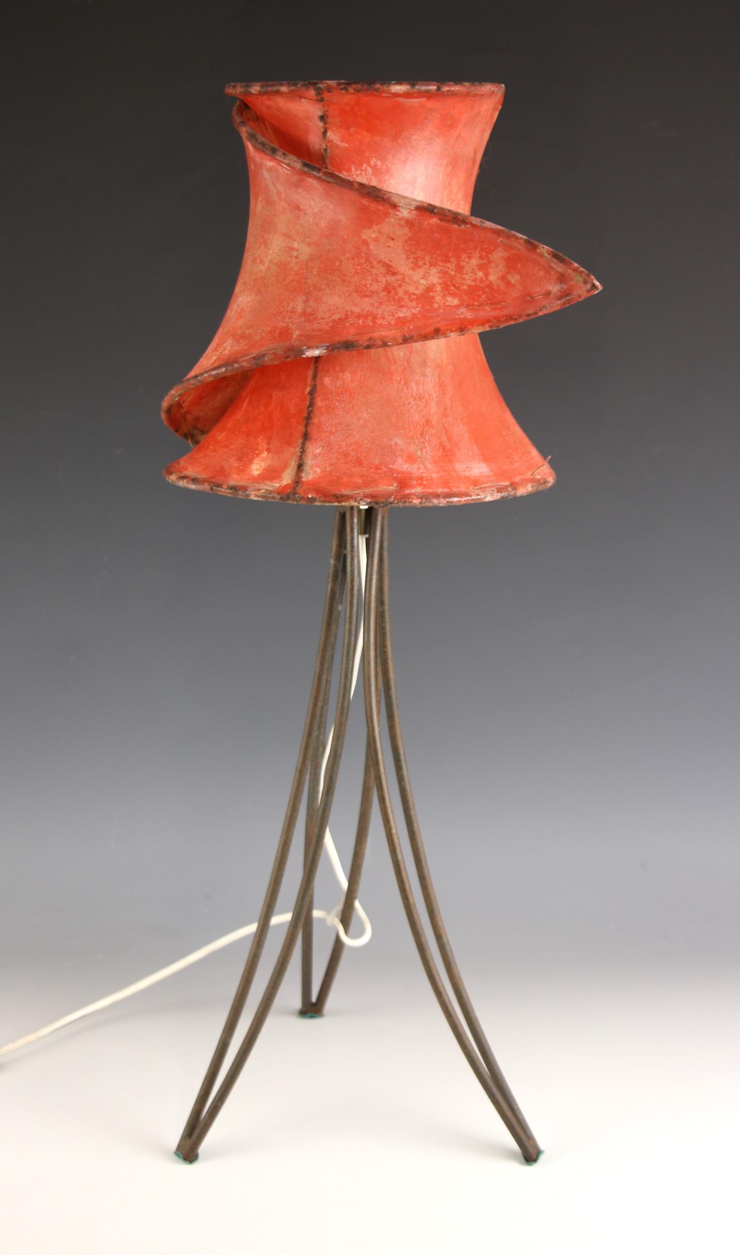 A mid 20th century vellum table lamp, the 'wrap-around' shade upon three iron hairpin type supports,