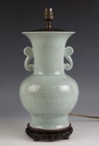 A Chinese porcelain celadon lamp base, with all over scrolling leaf and vine decoration, hardwood