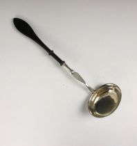 A continental white metal ladle, the oval bowl with gilt interior leading to split and tapered