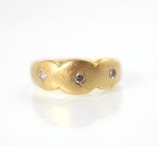 A yellow metal and diamond bespoke ring, of organic triple rounded form set with three round cut