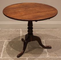 A George III oak tripod table, the circular tilt top upon a turned and tapering column extending