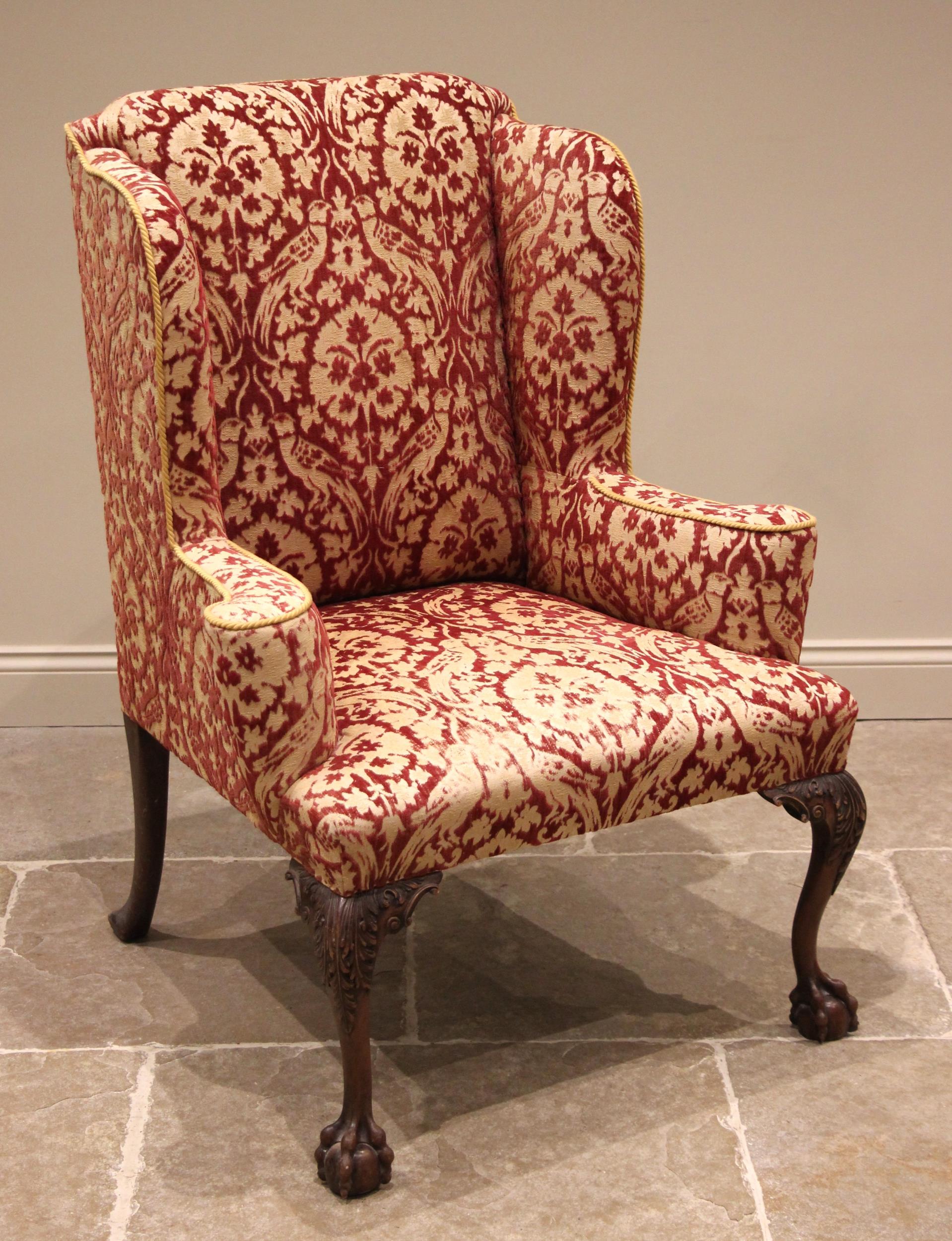 A George III style wing back armchair, mid 20th century, of country house proportions, in embossed