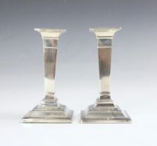 A pair of George V silver candlesticks, Henry Matthews, Birmingham 1911, the square shaped