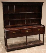 An 18th century oak dresser, the rack with a moulded cornice over a plain frieze applied with iron