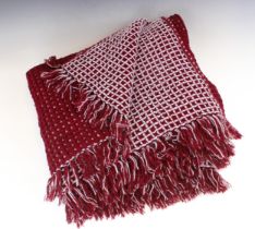 A Welsh wool reversible honeycomb blanket, in burgundy and light blue colourway, with fringe to