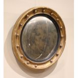 A Regency giltwood and gesso circular convex wall mirror, the circular moulded frame applied with