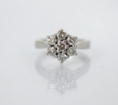 A mid 20th century diamond set cluster ring, the central round cut diamond within surround of six