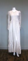 A 1940s ivory velvet full length wedding dress, with long sleeves, ruffled detail to fronts and hem,