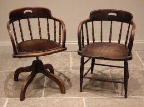 An oak revolving office desk chair, early 20th century, the spindle back over a studded pad bowfront