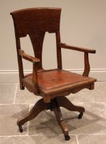 An early 20th century oak desk chair, the shaped back with pierced splat over a padded leather