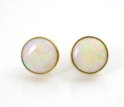 A pair of 9ct yellow gold mounted opal earrings, of circular cabochon form, within rubover yellow