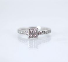 A platinum and diamond ring, the four square cut diamonds channel set in a raised mount, with