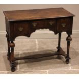 A William and Mary style figured walnut low boy, 19th century, the book veneered moulded top over an