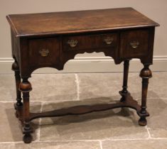 A William and Mary style figured walnut low boy, 19th century, the book veneered moulded top over an