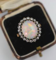 A 19th century precious opal and diamond cluster ring, the oval cabochon opal claw set within a
